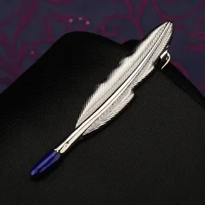 Dettaglio fermacravatta a piuma argentata, elegante accessorio da uomo per abito formale aziendale.