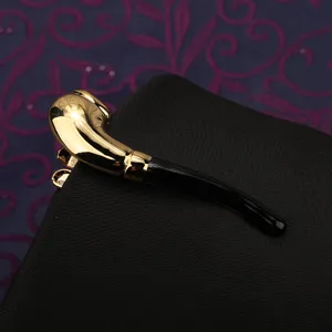 Primo piano dettagliato di un'elegante fermacravatta dorata e nera a forma di pipa per uomo.