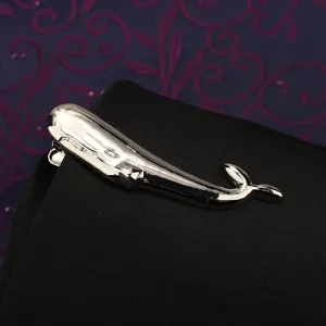 Dettaglio fermacravatta balena argento, design in metallo elegante per abito formale uomo.