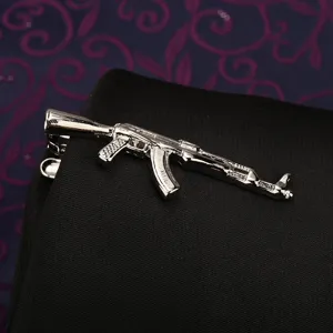 Primo piano dettaglio fermacravatta argento forma fucile, finitura metallo, uomo.