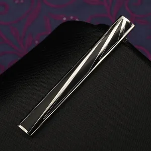 Primo piano dettagliato di un elegante fermacravatta geometrico argento e nero.