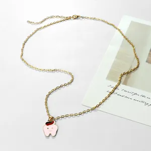 Collana con catena per clavicola color oro con grazioso ciondolo smaltato a dente ammiccante.