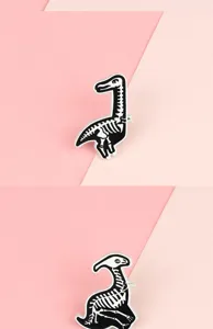 Black and white alloy dinosaur skeleton lapel pin detail shot, creative gothic metal badge.