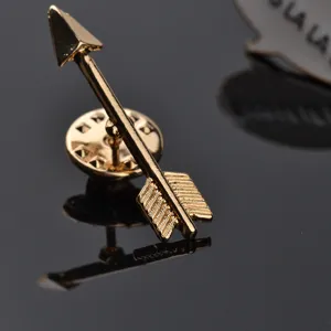Exquisite gold arrow lapel pin detailed macro shot, stylish alloy brooch badge for men and women.