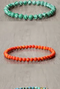 Vue détaillée de bracelets de perles en pierre rayée colorée, élastiques.