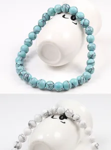 Vue détaillée de bracelets élastiques en turquoise et perles de pierre avec texture.