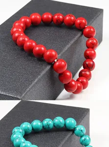 Vue détaillée de bracelets de perles en pierre colorée avec des veines noires sur boîte.