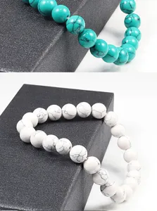 Gros plan de bracelets extensibles en perles de pierre turquoise et blanche sur boite.