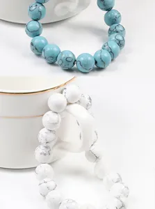 Détail de bracelet en perles de turquoise avec veinage noir naturel et design élastique.