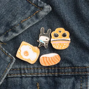 Close-up detail of cute Japanese style enamel pins featuring cartoon food and ninja rabbit.