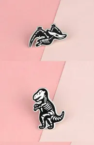 Black and white alloy dinosaur skeleton brooch detail shot showing intricate bone design.
