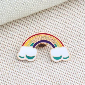 Primo piano dettagliato di una bellissima spilla colorata con arcobaleno e unicorno.