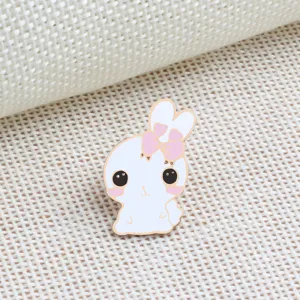 Spilla smaltata con coniglietto bianco e fiocco rosa, deliziosa decorazione per abbigliamento.