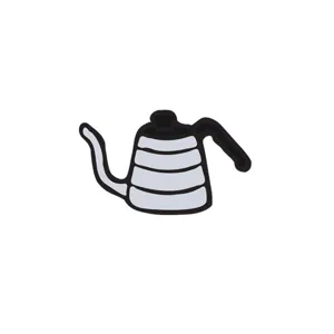 Detailed view of a charming kettle shaped enamel pin, perfect for coffee and tea lovers.
