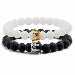 Set di bracciali in turchese bianco e pietra lavica nera con ciondolo a corona elegante.