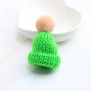 Mini green knit hat brooch charm, detailed close-up of cute sweater ornament and bag pendant.