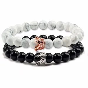Set di bracciali di coppia in perle di turchese bianco e pietra nera con ciondolo a corona.