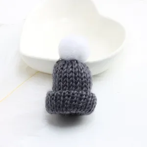 Detailed view of the cute grey knitted hat brooch with white pom-pom, perfect accessory.