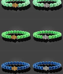Détails en gros plan de bracelets en perles de pierres précieuses avec des breloques Hamsa.