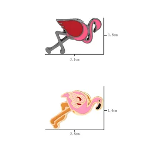 Close-up detail view of cute flamingo enamel brooch pins featuring metallic finish and vibrant pink colors.