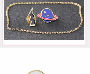 Nahaufnahme des kreativen Planeten und Blitz Emaille Brosche Set mit Kette aus Legierung.