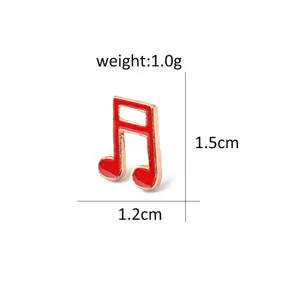 Detail view of a cute red and gold enamel music note brooch pin, compact size and alloy.