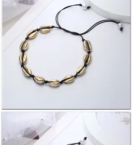 Dettaglio collana girocollo con conchiglie cauri placcate oro in stile hawaiano nero.