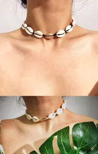 Detailansicht der Strand Muschel Choker Halskette mit schwarzem Band und goldenem Muschel Anhänger.