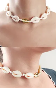 Details der Kauri-Muschel-Choker-Halskette zeigen weiße und goldene Muscheltextur und Knoten.
