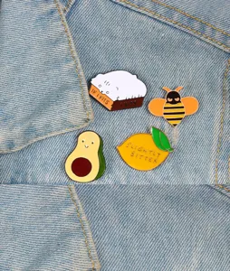 Detailed view of cute cartoon alloy enamel pins featuring a cat, bee, avocado, and lemon design.