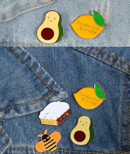 Cartoon enamel pin set detail showcasing cute avocado, lemon and cat brooch designs for bags.
