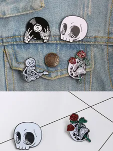 Gros plan sur les broches en métal émaillé style punk d'Halloween avec crâne et guitare rose.