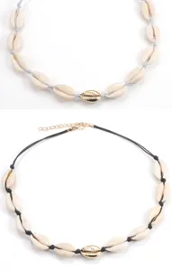 Nahaufnahme Details der natürlichen weißen Muschel Choker Halskette mit goldenem Akzent.