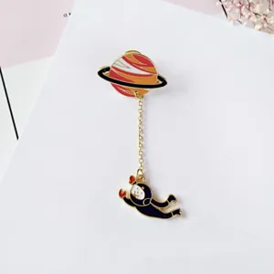 Creative planet astronaut alloy brooch with chain, stylish drip oil pin for clothing and hats.