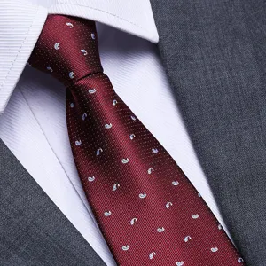 Burgundy red men's business suit tie fabric detail close up showing fine woven whale pattern.