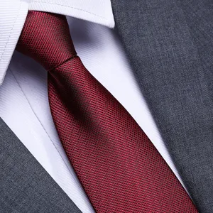 Close-up detail of a textured red business necktie paired with a classic white shirt.