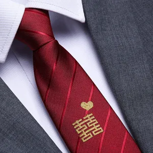 Close-up detail of red wedding necktie with gold embroidered double happiness and heart.