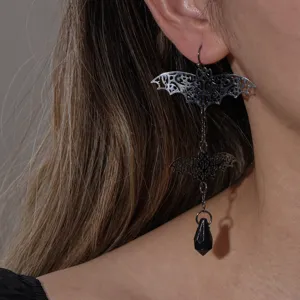 Gothic bat dangle earrings close-up, intricate cutout metal design with black crystal drop.