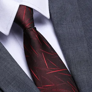 Close-up detail of a stylish men's business necktie with red abstract lines on dark fabric.