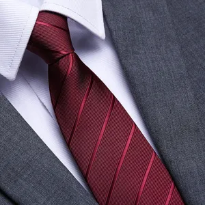 Close-up detail of a mens red striped business tie paired with a crisp white shirt and suit.