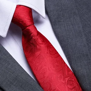 Red patterned necktie close up detail, formal wedding business suit accessory texture view.
