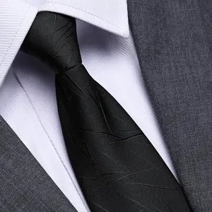 Primo piano dettagliato della cravatta da lavoro nera con trama a linee geometriche.