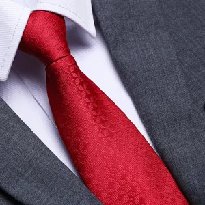 Close up detail of a red woven necktie paired with white shirt for formal business suit.