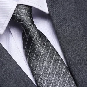 Primo piano dettagliato di una cravatta formale grigia a righe da uomo abbinata a camicia.
