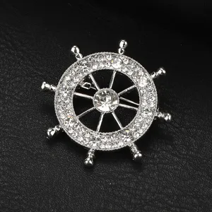 Spilla timone nave in strass argento, elegante accessorio per risvolto abito nautico.