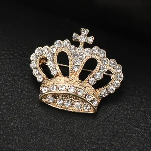 Primo piano dettagliato di una spilla a corona dorata intarsiata di strass trasparenti.