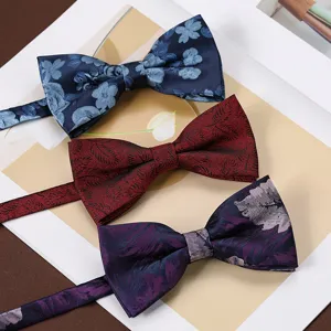 Primo piano dettagliato di tre papillon fantasia in tessuti jacquard blu, rosso e viola.
