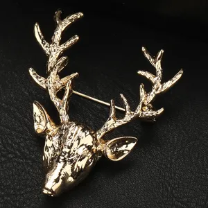 Dettaglio spilla testa di cervo dorata, squisita trama metallica, elegante accessorio per abito.