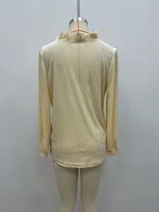 Détail de dos d'un haut en velours à manches longues pour femme en jaune pastel.