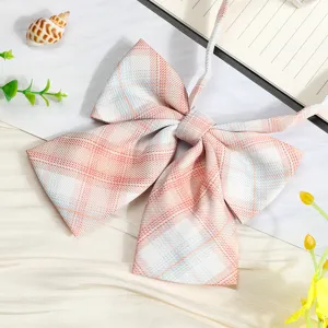 Close up detail view of pink plaid JK school uniform bow tie with ribbon collar accessory.